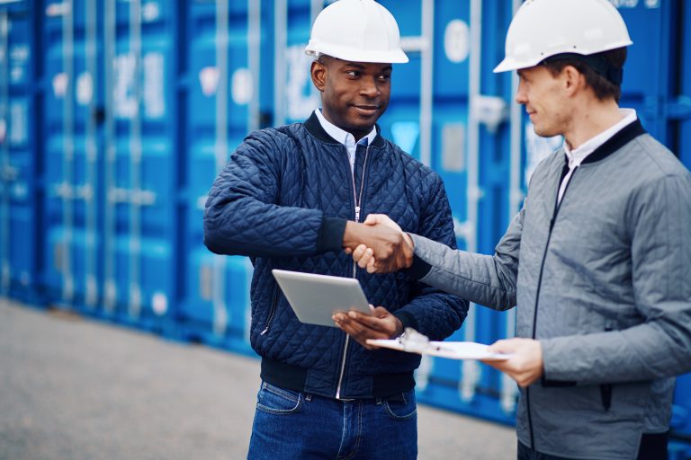 business men handshake near blue cargo containers 2026 03 09 05 22 31 utc