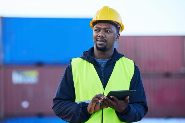 Tablet, black man and cargo planning logistics for shipping company, shipyard and container storage.