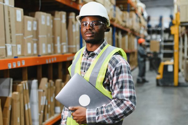 portrait of a smiling young warehouse worker working in a cash and carry wholesale store.