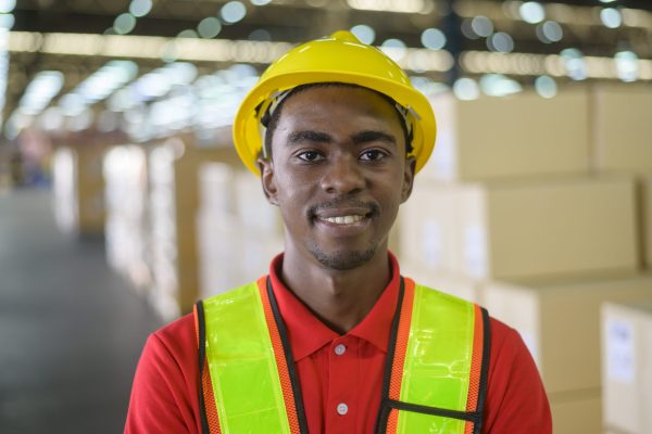 Male worker wearing helmet in warehouse storage